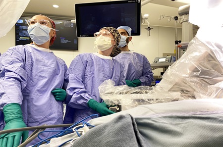 Surgical team observes monitor during robotic kidney surgery.
